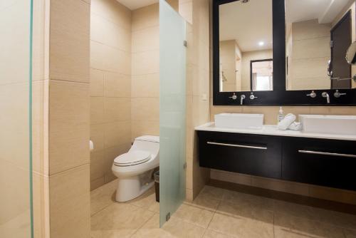 a bathroom with a toilet and a sink and a mirror at Beach Apartment At Nikki Residences 2 Bedroom in El Chirú