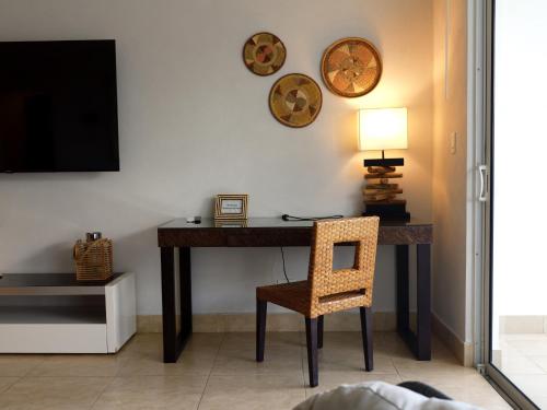 a room with a desk with a chair and a television at Beach Apartment At Nikki Residences 2 Bedroom in El Chirú