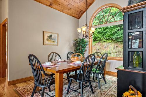 a dining room with a table and chairs and a window at Sky View - Luxury Mountain Golf Home in Whittier