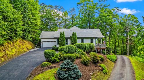a house with bushes and trees on a driveway at Sky View - Luxury Mountain Golf Home in Whittier