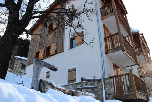 a building with wooden windows in the snow at Résidence Belvedere Busseroles - RESIDENCE LE BELVEDERE "BUSSEROLES" - BELVB06 MAE-3071 in Modane