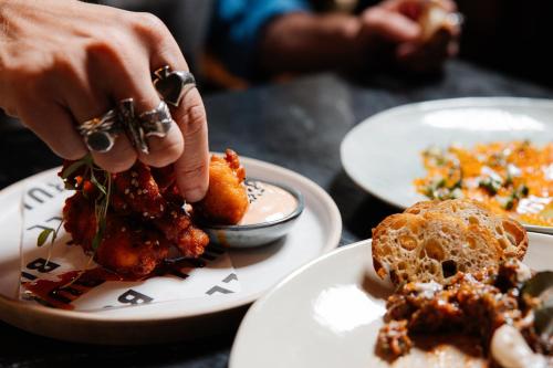 a person eating food on a table with plates of food at BULL Burford in Burford
