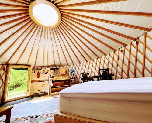 a room with a bed in a yurt with a window at Sky Nest Glamp-Unplug-Reconnect in Red Bay