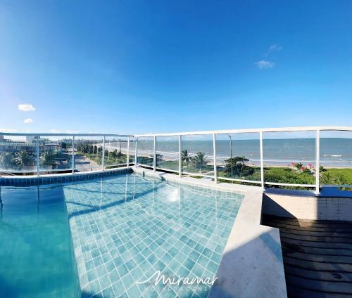 a swimming pool with a view of the ocean at Paradise Beira Mar-Miramar Hospedagens in Nossa Senhora do Livramento