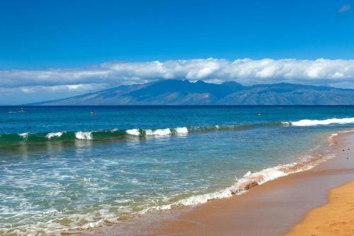 a view of the beach with mountains in the background at Honua Kai Luana Condos by KBM Resorts in Kaanapali