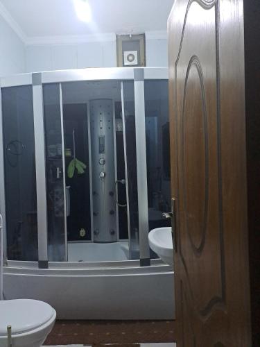 a bathroom with a toilet and a sink and a mirror at شقة مميزة in Rujm Maghghijhah