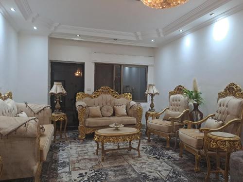 a living room with gold furniture and a chandelier at شقة مميزة in Rujm Maghghijhah