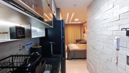 a room with a kitchen and a room with a bed at Açores Praia de Tamandaré - À Beira-Mar in Praia dos Carneiros