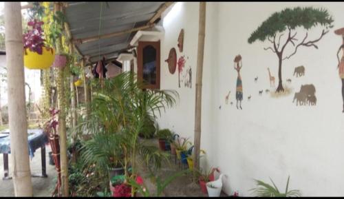 a white wall with a mural of animals on it at Sreemoyee Homestay in Hatikhuli