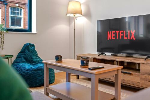 a living room with a tv and a coffee table at 2 Bed Modern Apartment in City Centre Birmingham in Birmingham