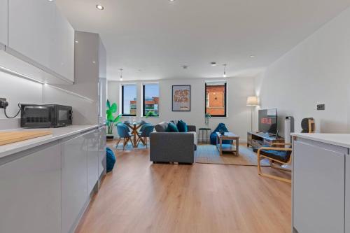 a kitchen and living room with a couch and a table at 2 Bed Modern Apartment in City Centre Birmingham in Birmingham