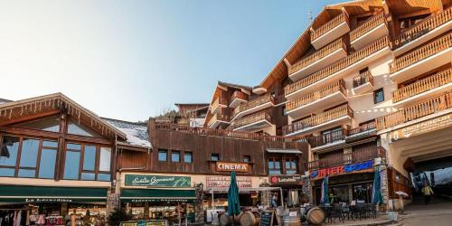 a large building with shops on the side of a street at Résidence Le Centre - Studio pour 4 Personnes MAE-3346 in Champagny-en-Vanoise