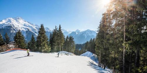 two people skiing down a snow covered slope with mountains at Résidence Le Centre - Studio pour 4 Personnes MAE-3346 in Champagny-en-Vanoise