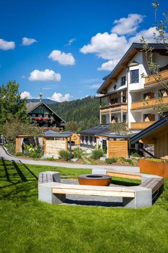 a park with a bench in front of a building at Hotel Pongauerhof in Flachau