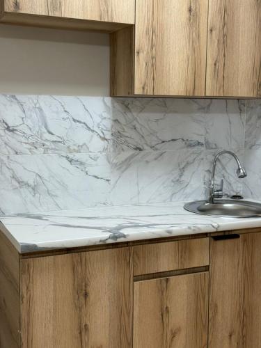 eine Küchentheke mit einer Spüle und einer Marmorarbeitsplatte in der Unterkunft Фучика 50 in Zhezdi