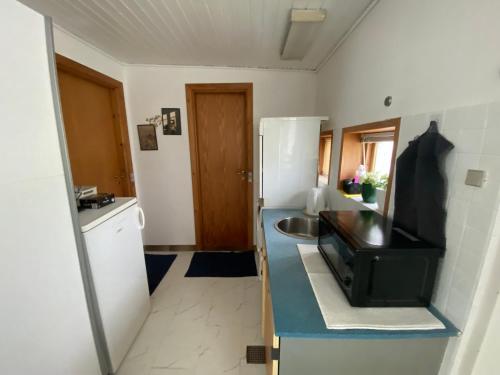 a small kitchen with a sink and a refrigerator at Family room in centrum 300m to Lego House and walking street in Billund
