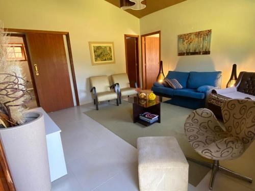 a living room with a blue couch and chairs at Casa DoZé in Espera Feliz