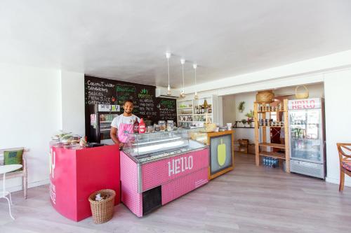 a man is standing behind a counter in a restaurant at CARIBBEAN VILLAS and SUITES - LOS CORALES beach - free wifi, free breakfast in Punta Cana