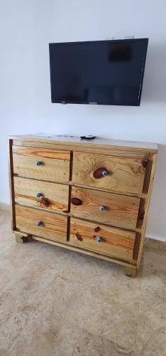 a wooden dresser with a tv on top of it at Bella Villa Roomy apartment at 5 min walk to the beach in Las Galeras