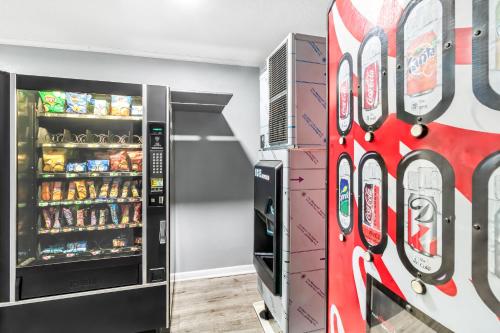 a soda machine in a room with a refrigerator at HomeTowne Studios by Red Roof Florence, KY-Cincinnati Airport in Florence