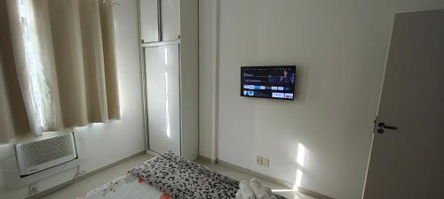 a room with a bed and a tv on the wall at Temporada Copacabana Salu 2 in Rio de Janeiro
