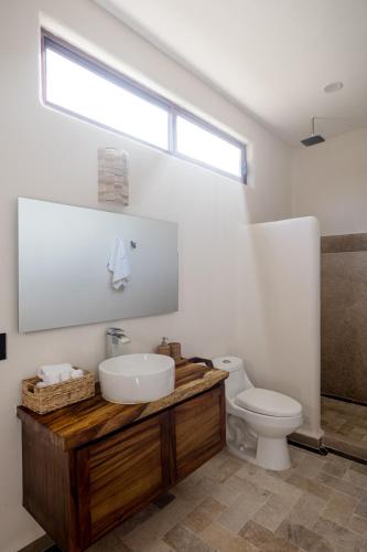 a bathroom with a sink and a toilet and a window at Isla Neptuno in Puerto Escondido