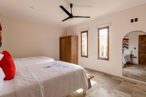 a bedroom with two beds and a ceiling fan at Isla Neptuno in Puerto Escondido