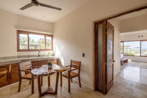 a kitchen with a table and chairs and a sink at Isla Neptuno in Puerto Escondido