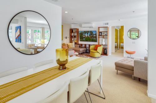 ein Wohnzimmer mit einem Tisch und einem Spiegel in der Unterkunft Chic Downtown Bungalow in Palm Springs
