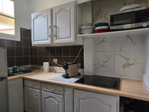 a kitchen with white cabinets and a counter top at MONACO 3mn du casino in Beausoleil
