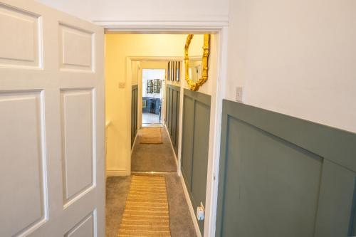 a hallway with yellow walls and a white door at The Narrow House - Victorian house bursting with character & parking in Chester