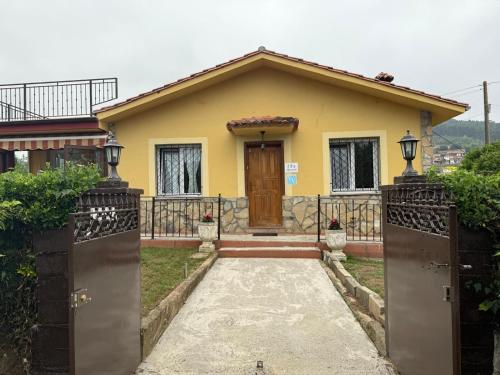 a yellow house with a gate in front of it at 3Raigaños Vivienda Vacacional in Sales
