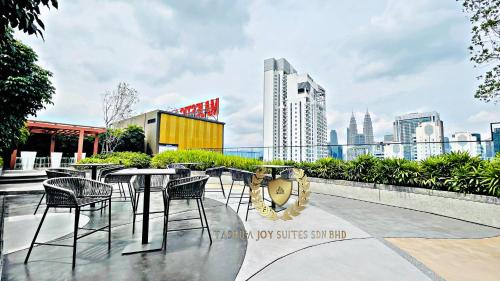 a patio with tables and chairs and a city skyline at Kuala Lumpur Luxury Suites By Majestic Residence in Kuala Lumpur
