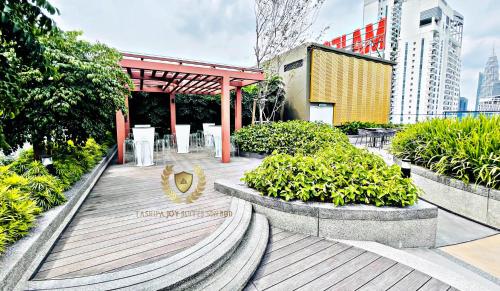 a wooden boardwalk with tables and plants in a city at Kuala Lumpur Luxury Suites By Majestic Residence in Kuala Lumpur