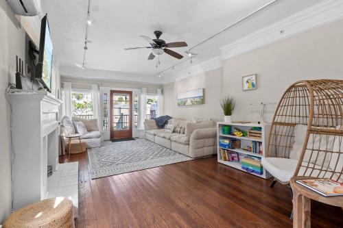 a living room with white walls and a ceiling fan at Historic Home with Modern Upgrades - Prime Downtown Location in Fort Pierce