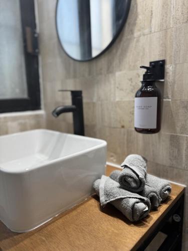 a bathroom sink with a towel and a bottle of soap at The Boat House Suites in Cancún