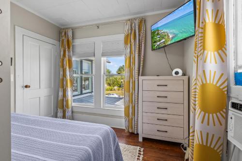 a bedroom with a bed and a flat screen tv at Historic Home with Modern Upgrades - Prime Downtown Location in Fort Pierce
