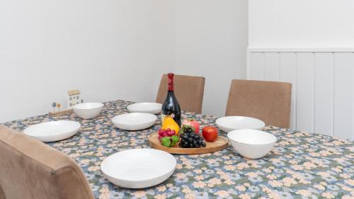 a table with white bowls and a bottle of wine and fruit at The Perfect Location in Southampton