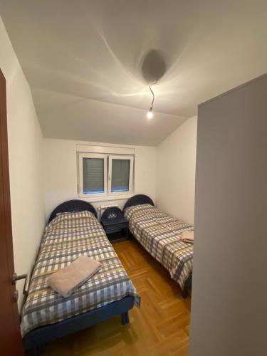 two beds in a room with two windows at Stan na dan Maxa&Bilja in Požarevac