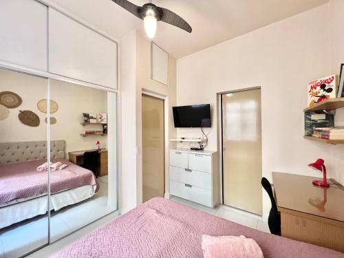 a bedroom with a bed and a mirror at Apartamento pertinho da praia e do metrô in Rio de Janeiro