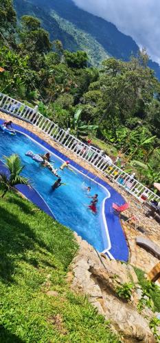 a group of people swimming in a large swimming pool at Finca Campestre Rancho Alegre in Fusagasuga