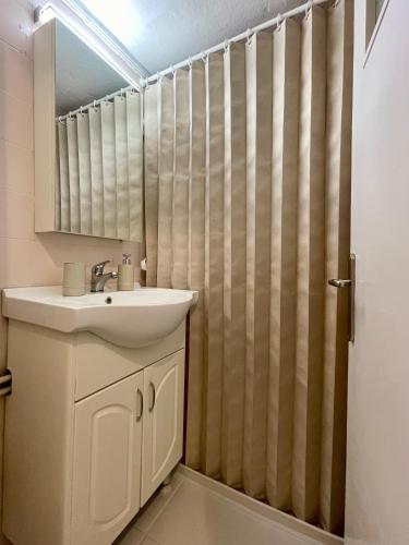 a bathroom with a sink and a shower curtain at Basic Stay in Xanthi