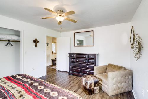 a bedroom with a ceiling fan and a chair and a dresser at Wine Tours and Antiquing Townhome Near Dtwn Brenham in Brenham