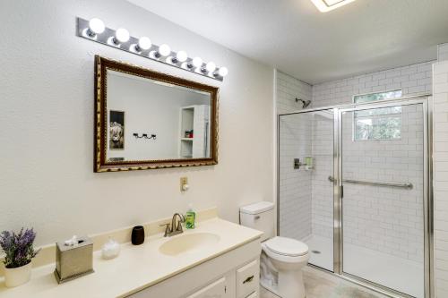 a bathroom with a toilet and a sink and a mirror at Wine Tours and Antiquing Townhome Near Dtwn Brenham in Brenham
