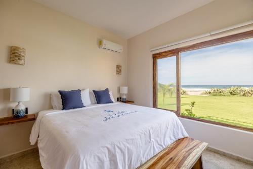 a bedroom with a large bed and a large window at Isla Neptuno in Puerto Escondido