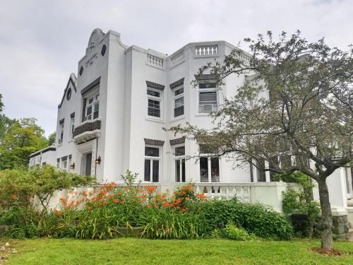 una casa bianca con dei fiori davanti di Waterfront Retreat Center a New Rochelle