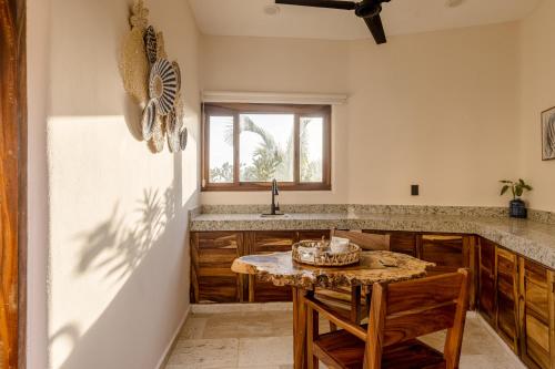 a kitchen with a table and a sink and a window at Isla Neptuno in Puerto Escondido