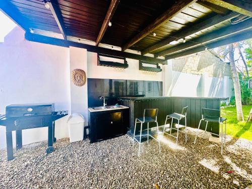 a kitchen with a stove and a table and chairs at HappiCasaRD & Holistic House in Sosúa