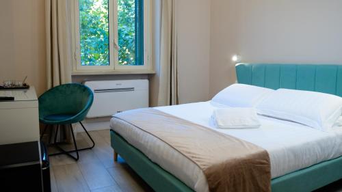 a bedroom with a bed and a chair and a window at Suites 215 Colosseum - Guesthouse in Rome