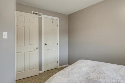 a bedroom with white doors and a bed in it at Townhome 10 Mi to WPAFB and Dayton! in Beavercreek
